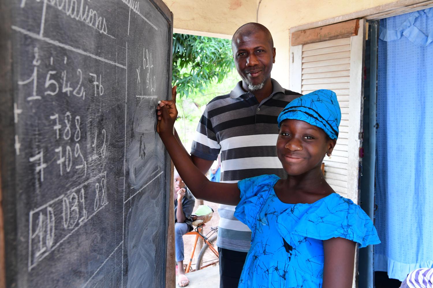 Fatimata Bagayogo, a 11 years old girl, is studying at home during the corona crisis, in Odienné, in the North of Côte d'Ivoire. As schools are closed, she's attending classes on television and also practicing on a billboard her father bought. Sidiki Bagayogo, a 47 years old men is a teacher, and knows the importance of education. "I like my father helps me. He does not oblige me. I like to study and I miss school. I miss my friends but now I help my mother to cook when I'm bored. Later I want to become a doctor. " says the young girl. For every child, education.