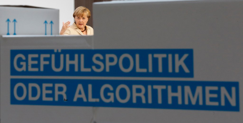 German Chancellor Angela Merkel speaks during the Alfred Herrhausen Conference at the Deutsche Bank building in Berlin, September 28, 2012. The German words in the foreground translate "Politics of Emotion instead of Algorithms."  REUTERS/Thomas Peter (GERMANY - Tags: POLITICS BUSINESS TPX IMAGES OF THE DAY)