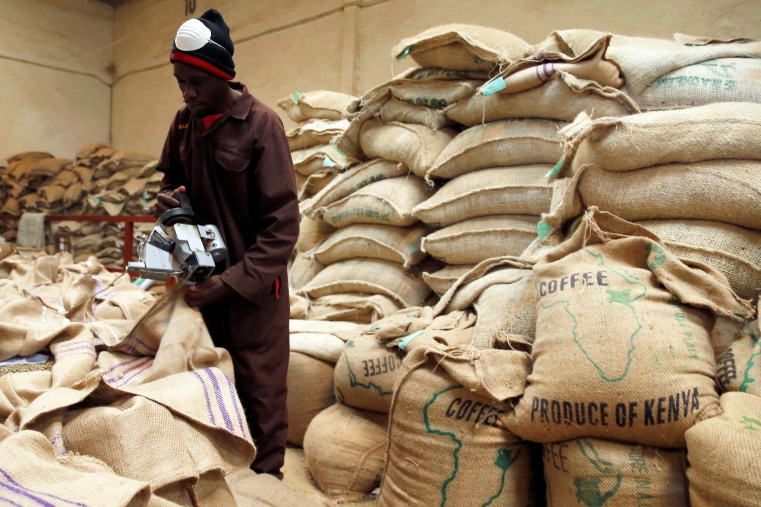 An employee closes coffee bags at the Central Kenya Coffee Mill near Nyeri, Kenya, March 15, 2018. Picture taken March 15, 2018. REUTERS/Baz Ratner