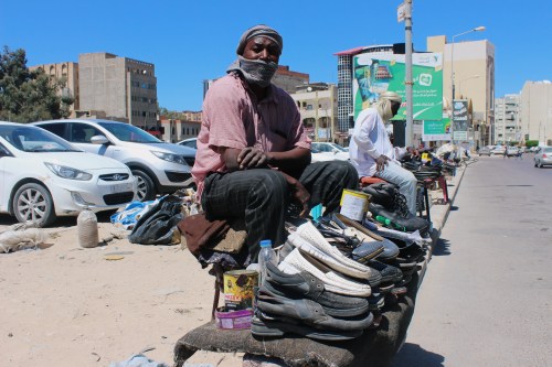 A migrant sells old shoes as he sits on the side of a road, following the outbreak of the coronavirus disease (COVID-19), during the holy month of Ramadan in Misrata, Libya May 3, 2020. Picture taken May 3, 2020. REUTERS/Ayman Al-Sahili
