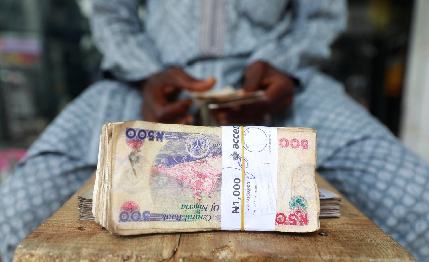 A money changer counts Nigerian currency notes for a customer in Nigeria's commercial capital, Lagos, Nigeria March 16, 2020. REUTERS/Temilade Adelaja