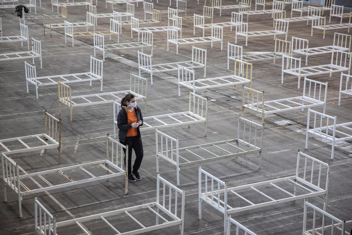 A volunteer walks as Serbian military set beds inside the Novi Sad Fair to accommodate people who suffer mild symptoms of coronavirus disease (COVID-19) in Novi Sad, Serbia, March 27, 2020. REUTERS/Marko Djurica