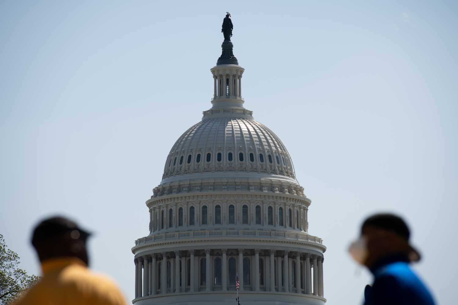 A general view of the U.S. Capitol Building as seen with masked pedestrians speaking in the foreground, in Washington, D.C., on May 13, 2020 amid the Coronavirus pandemic. Today as the American death toll neared 85,000, the Chairman of the Federal Reserve warned that the potential economic cost of the COVID-19 pandemic had no modern precedent, and without strong Congressional action it could cause a wave of bankruptcies leading to permanent economic damage.(Graeme Sloan/Sipa USA)No Use UK. No Use Germany.