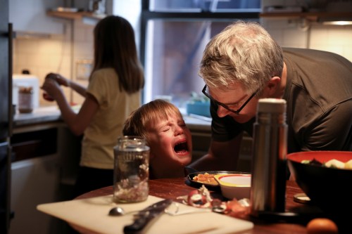 Felix Hassebroek is comforted by his father after dropping food at lunch during the outbreak of the coronavirus disease (COVID-19) in Brooklyn, New York City, New York, U.S., April 24, 2020. REUTERS/Caitlin Ochs