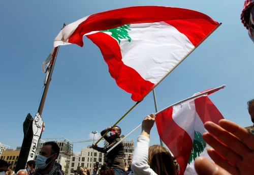 Demonstrators, wearing masks as preventive measures against the spread of coronavirus disease (COVID-19), gesture and carry Lebanese flags during a protest against the growing economic hardship and to mark Labour Day in Beirut, Lebanon May 1, 2020. REUTERS/Mohamed Azakir