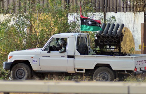 A fighter from irregular forces loyal to former army general Khalifa Haftar drives an armed vehicle with the Libyan flag during clashes with Islamist militants in the eastern city of Benghazi June 2, 2014. Eight people were killed and 15 wounded when fighting broke out on Monday between the Libyan army and Islamist militants in Benghazi, medical sources said. The Ansar al-Sharia militant group attacked a camp on Monday belonging to army special forces, residents there said. Forces of the renegade general fighting Islamists later joined the battle, using combat helicopters, they added.   REUTERS/Stringer (LIBYA - Tags: CIVIL UNREST POLITICS)
