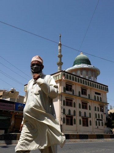 A man with a protective mask walks past a mosque in tha background, during a lockdown in efforts to stem the spread of the coronavirus disease (COVID-19), in Karachi, Pakistan May 1, 2020. REUTERS/Akhtar Soomro