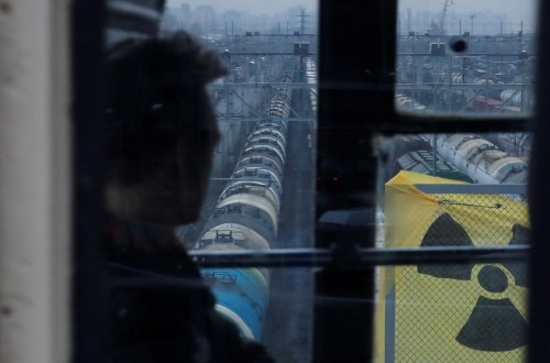 A passenger is seen through a window of a tram, which drives past a banner spread out by Greenpeace activists during a protest against the arrival of "Mikhail Dudin" cargo ship reportedly carrying nuclear wastes from Germany in Saint Petersburg, Russia November 28, 2019. REUTERS/Anton Vaganov