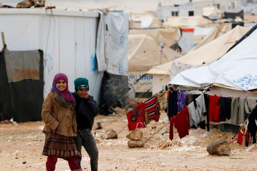 Syrian children smile after a heavy snowstorm at Al Zaatari refugee camp in the Jordanian city of Mafraq, near the border with Syria, January  8, 2015. Syrian refugees in Jordan's main Zaatari refugee camp appealed for help on Thursday after a regional storm buffeted the Middle East with blizzards, rain and strong winds. The temperatures, which usually average 13 Celsius (55.4 Fahrenheit ) this time of the year have plunged to 2 to zero Celsius (35.6-32 Fahrenheit), Jordan Meteorological Department (JMD) said on Tuesday. REUTERS/Muhammad Hamed (JORDAN - Tags: ENVIRONMENT CONFLICT)