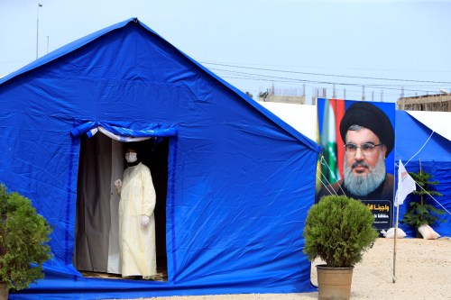 A medic wearing protective gear stands inside a tent facility set up by Hezbollah to test for coronavirus disease (COVID-19) in al-Ghaziyeh, southern Lebanon March 31, 2020. Picture taken March 31, 2020. REUTERS/Ali Hashisho