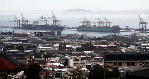 Container ships wait to load and offload goods in port in Cape Town, South Africa.