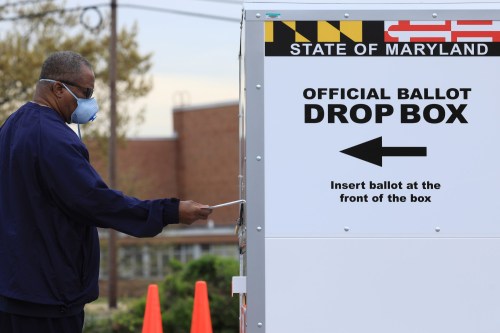 A resident drops off a mail-in ballot at the Edmondson Westside High School Polling site, during the special election for Maryland's 7th congressional district seat, previously held by Rep. Elijah Cummings (D-MD), in Baltimore, Maryland, U.S., April 28, 2020. REUTERS/Tom Brenner
