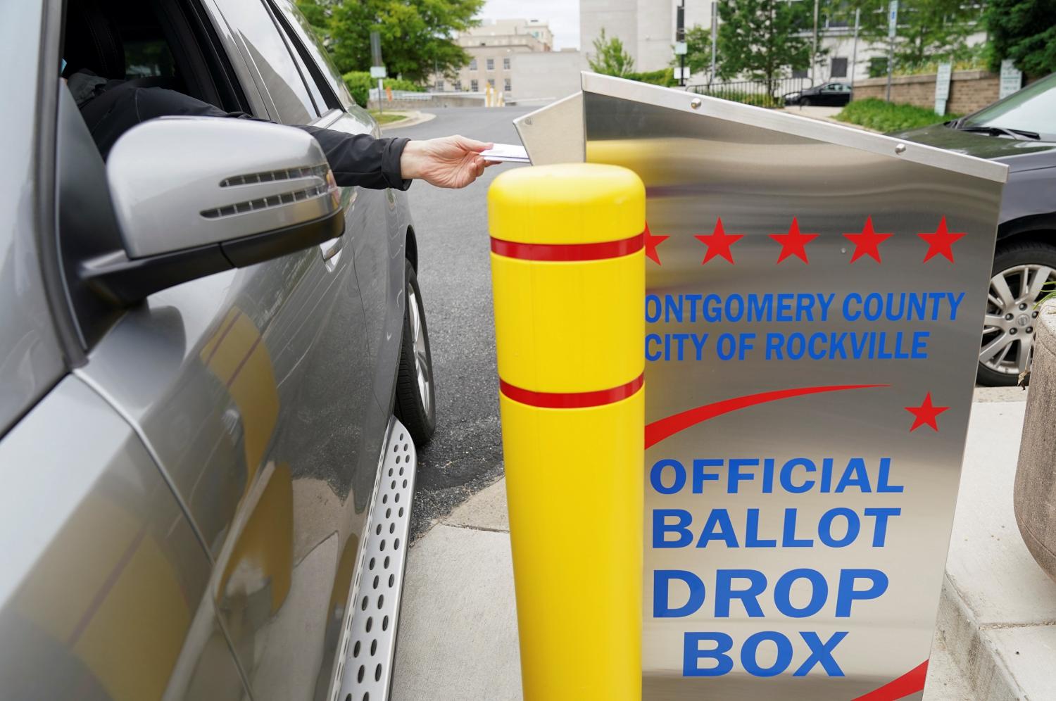 A man places his ballot into a drop box for Maryland's primary election in Rockville, Maryland, U.S., June 2, 2020. REUTERS/Kevin Lamarque