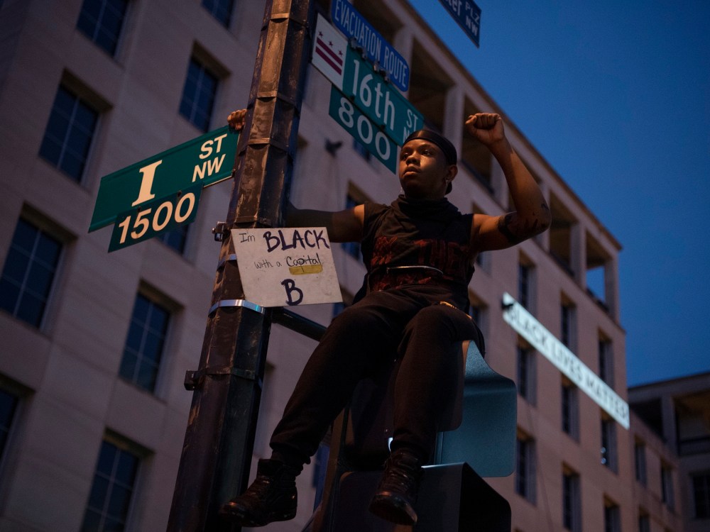 États-Unis - 06 juin: un jeune homme est assis au sommet d'un signal de rue sur la section de la 16e rue surnommée Black Lives Matter Plaza après une journée de manifestations pour honorer George Floyd et les victimes d'injustice raciale le samedi 6 juin 2020 (photo de Tom Williams / CQ Roll Call / Sipa USA) Pas d'utilisation au Royaume-Uni. Pas d'utilisation en Allemagne.