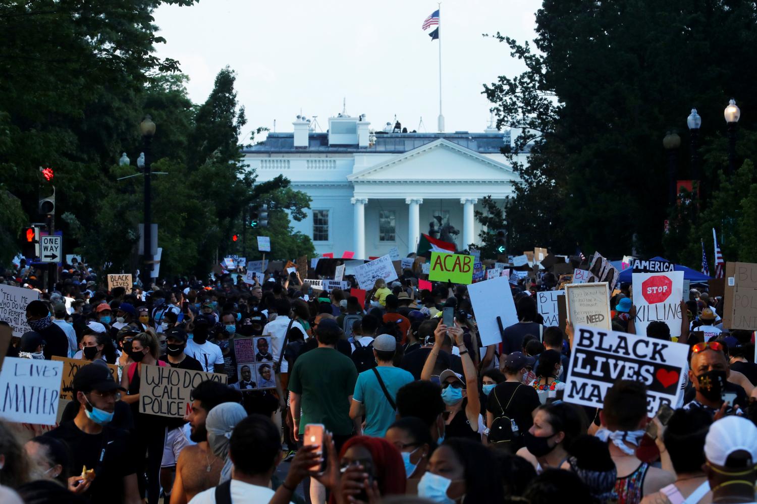 Demonstrators hold up signs at the "Black Lives Matter Plaza", near the White House, during a protest against racial inequality in the aftermath of the death in Minneapolis police custody of George Floyd, in Washington, U.S. June 6, 2020. REUTERS/Jim Bourg