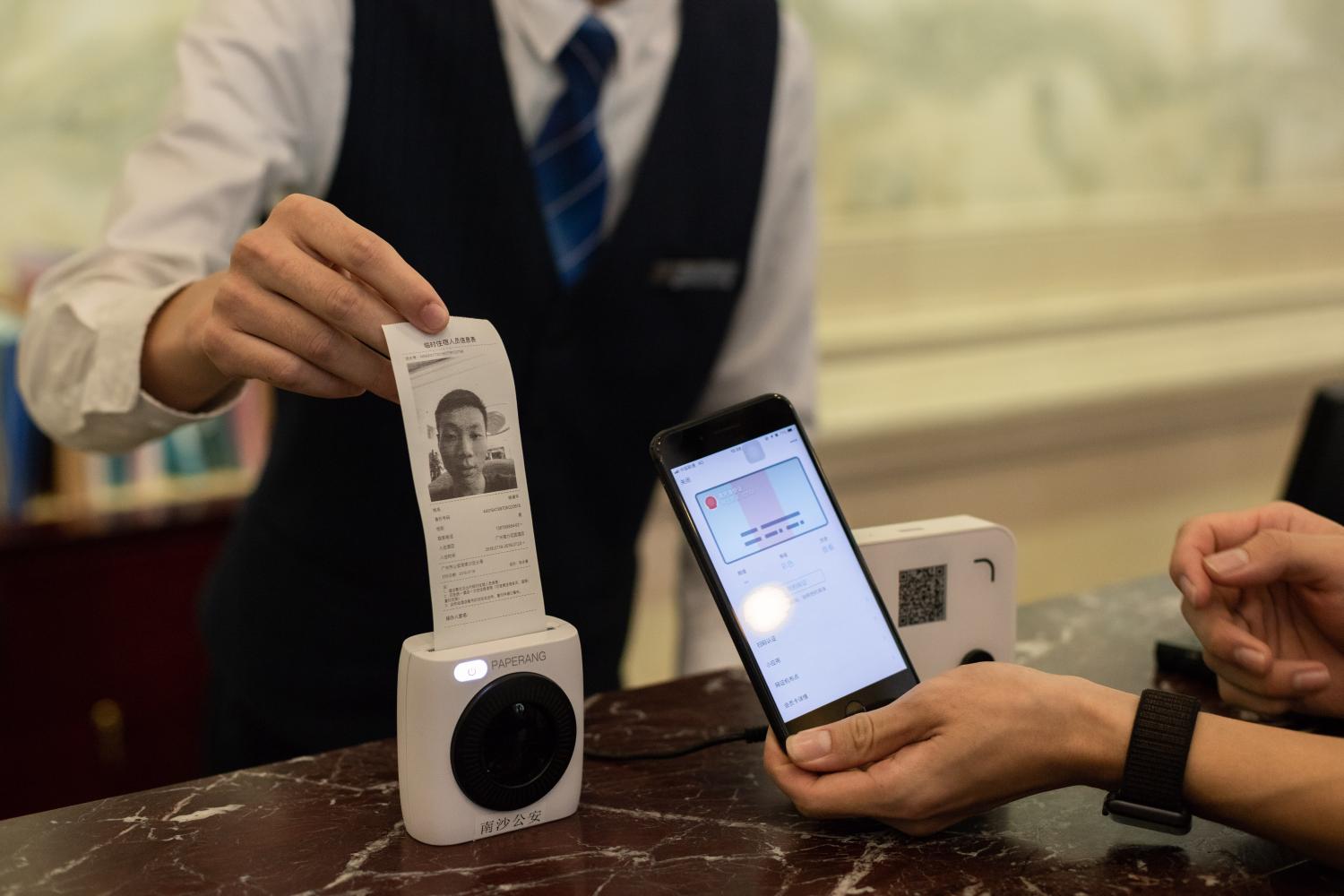 A Chinese mobile phone user uses his electronic identification card in the messaging app Weixin, or WeChat, of Tencent, on his smartphone to check in at a hotel in Guangzhou city, south China's Guangdong province, 19 July 2018.WeChat, the popular mobile messaging, social media and payments platform run by Tencent Holdings, is poised to become further entrenched in everyday life in China under a new programme that adapts it as a user's electronic social security card. China's Ministry of Human Resources and Social Security, backed by Hong Kong-listed Tencent, has started to roll out the project in 26 cities, including the southern coastal city of Shenzhen and Xi'an in the country's northwest. The WeChat-based electronic social security cards will enable users to provide their identification, status, payment records and other relevant information to official online inquiries about benefits and insurance coverage.No Use China. No Use France.