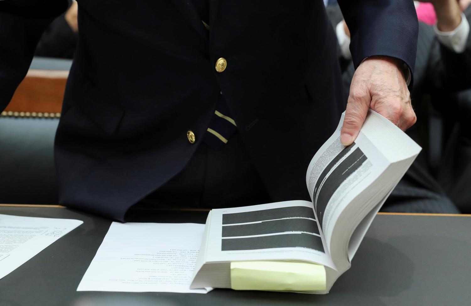Former White House counsel John Dean, a key figure in the Watergate scandal that toppled former President Richard Nixon, opens the report from Special Counsel Robert Mueller to a heavily redacted page as he prepares to testify before a House Judiciary Committee hearing entitled "Lessons from the Mueller Report" on Capitol Hill in Washington U.S., June 10, 2019.  REUTERS/Jonathan Ernst
