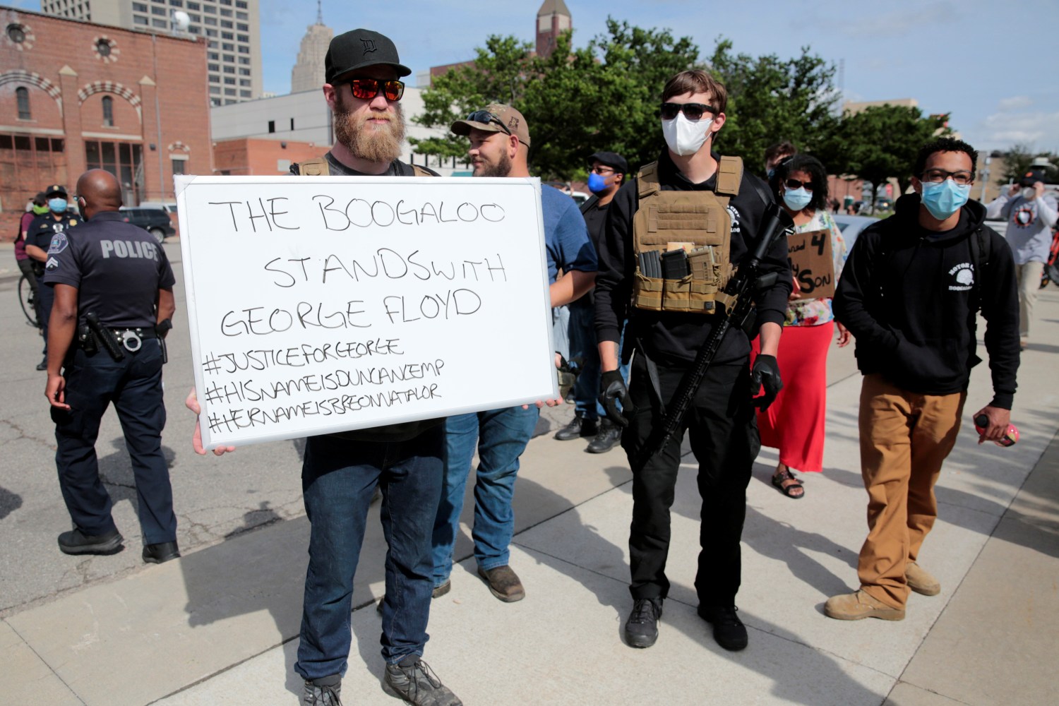 Armed men, one carrying a "The Boogaloo stands with George Floyd" sign, are seen as protesters rally against the death in Minneapolis police custody of George Floyd, in Detroit, Michigan, U.S. May 30, 2020. Picture taken May 30, 2020.   REUTERS/Rebecca Cook