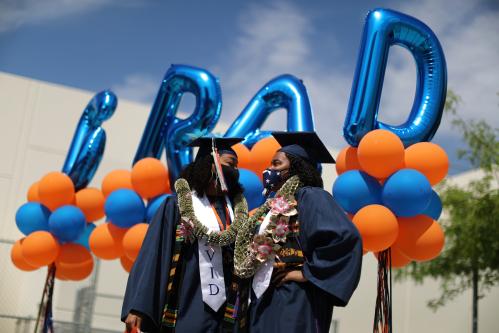 Students Laila Lacy, 17, and Ashley Williams, 17, stand in front of graduation balloons at a drive-thru graduation ceremony at University High School amid the coronavirus disease (COVID-19) outbreak, in Los Angeles, California, U.S., June 12, 2020. REUTERS/Lucy Nicholson