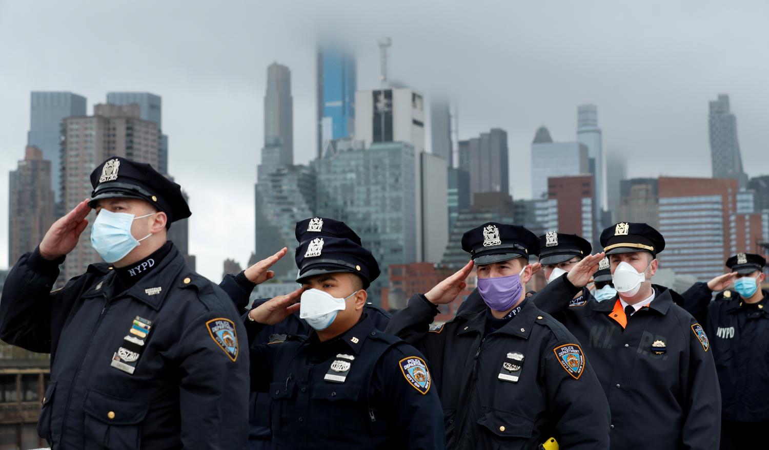 Police officers from the NYPD salute as the U.S. Navy hospital ship USNS Comfort departs Pier 90 in Manhattan under heavy fog to return to its home port of Norfolk, Virginia, after treating patients during the outbreak of the coronavirus (COVID-19) in New York City New York, U.S., April 30, 2020. REUTERS/Lucas Jackson     TPX IMAGES OF THE DAY