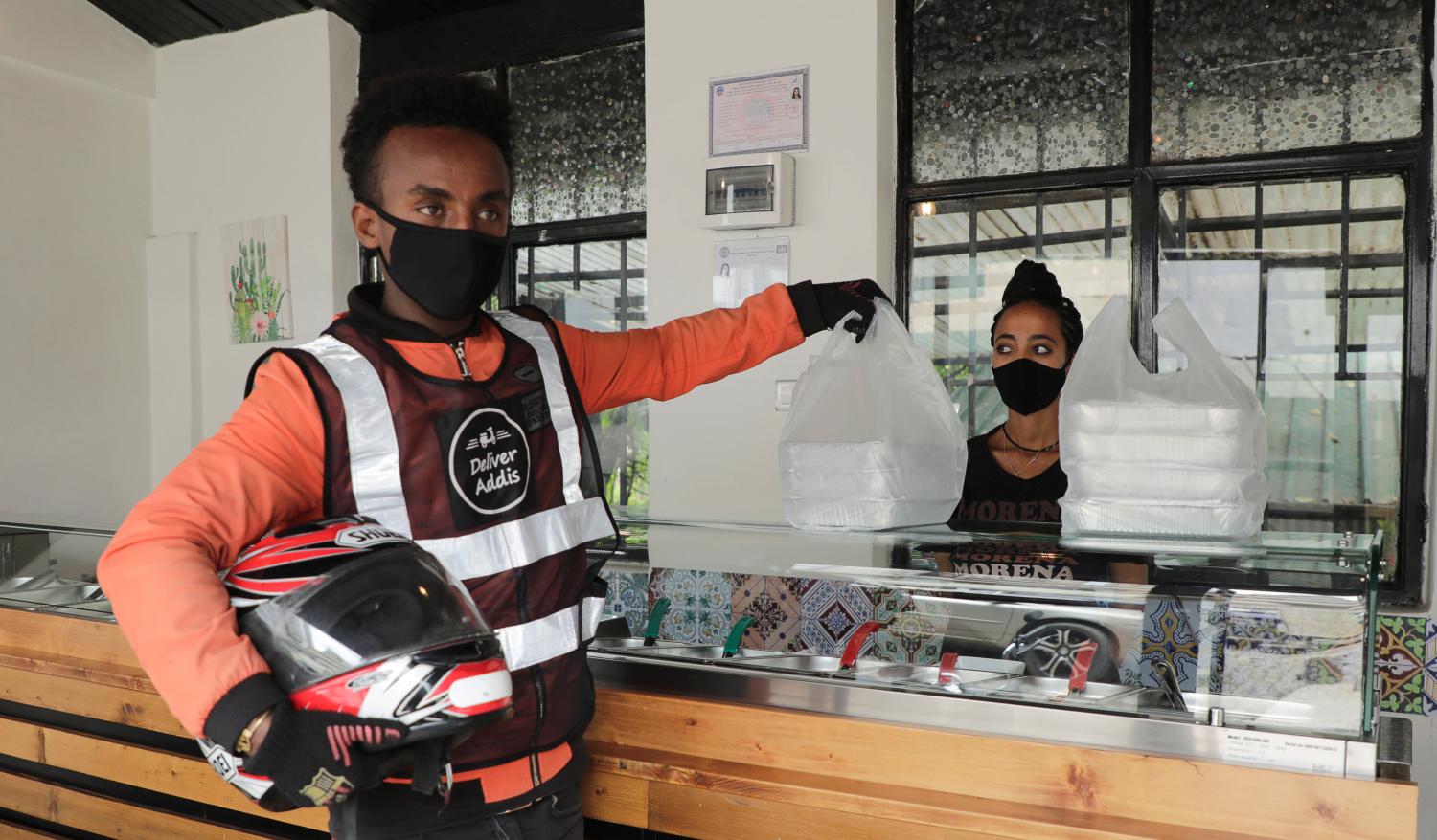 Biniam Nigussie, 21, a Deliver Addis motorbike rider picks up lunch boxes from La Morena restaurant to be delivered to clients working from home due to the spread of the coronavirus disease (COVID-19) in central Addis Ababa, Ethiopia June 3, 2020. REUTERS/Kumera Gemechu NO RESALES. NO ARCHIVES