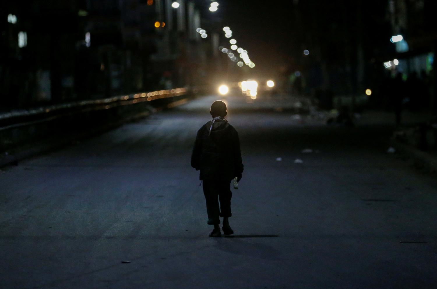 A child walks along the street at the start of the lockdown restrictions set by the government to prevent the rampant spread of the coronavirus disease (COVID-19), in Eastleigh district of Nairobi, Kenya May 6, 2020. REUTERS/Thomas Mukoya