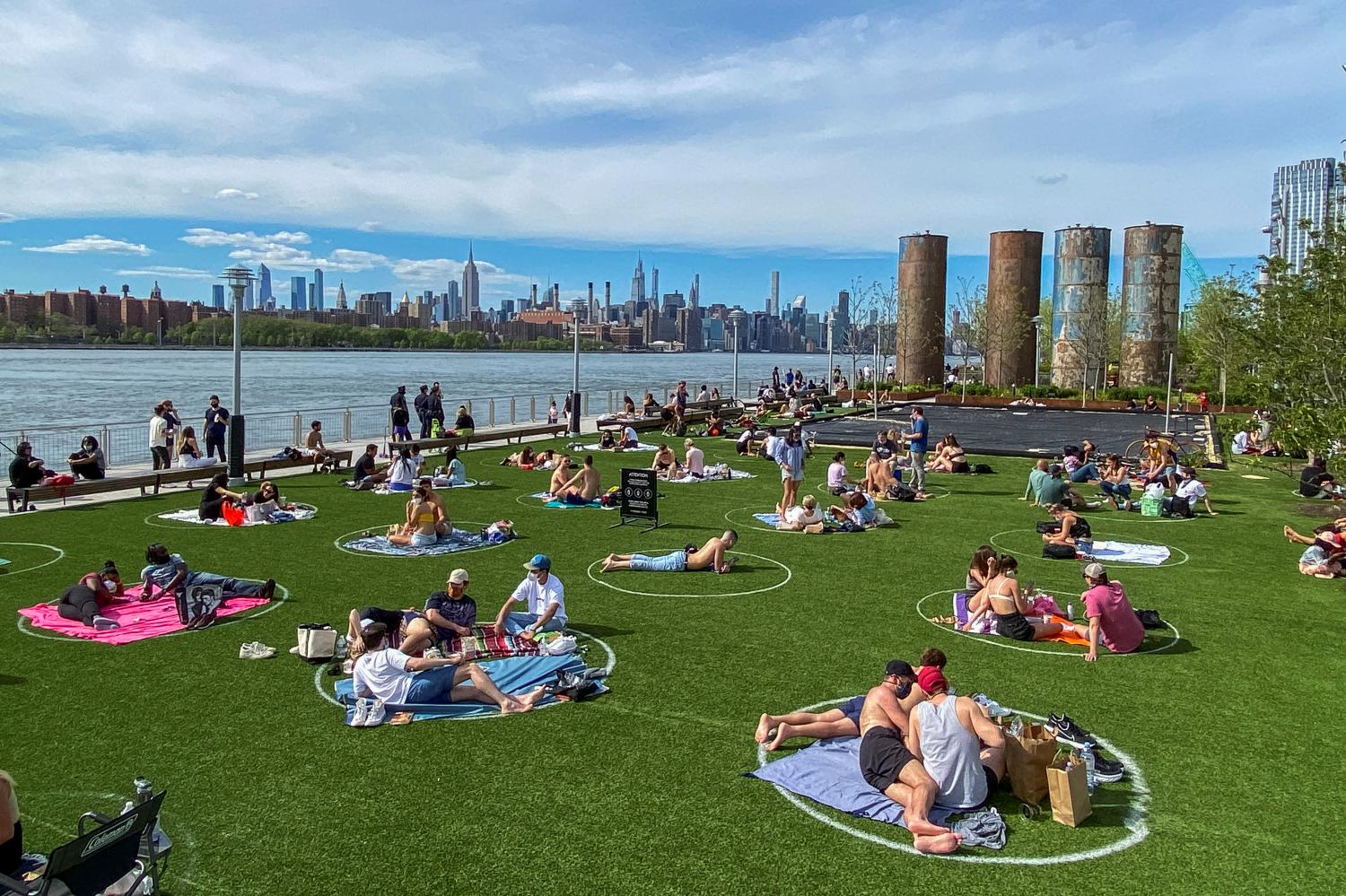 People try to keep social distance as they enjoy a warm afternoon during the outbreak of the coronavirus disease (COVID-19) at Domino Park in Brooklyn, New York, U.S., May 16, 2020. REUTERS/Eduardo Munoz