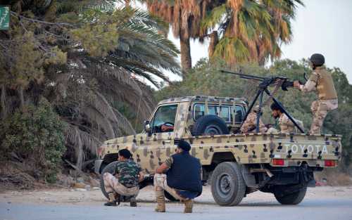 Irregular forces loyal to former army general Khalifa Haftar stand by an armed vehicle during clashes with Islamist militants in the eastern city of Benghazi June 2, 2014. Eight people were killed and 15 wounded when fighting broke out on Monday between the Libyan army and Islamist militants in the eastern city of Benghazi, medical sources said. The Ansar al-Sharia militant group attacked a camp on Monday belonging to army special forces, residents there said. Forces of the renegade general fighting Islamists later joined the battle, using combat helicopters, they added.   REUTERS/Stringer (LIBYA - Tags: CIVIL UNREST POLITICS)