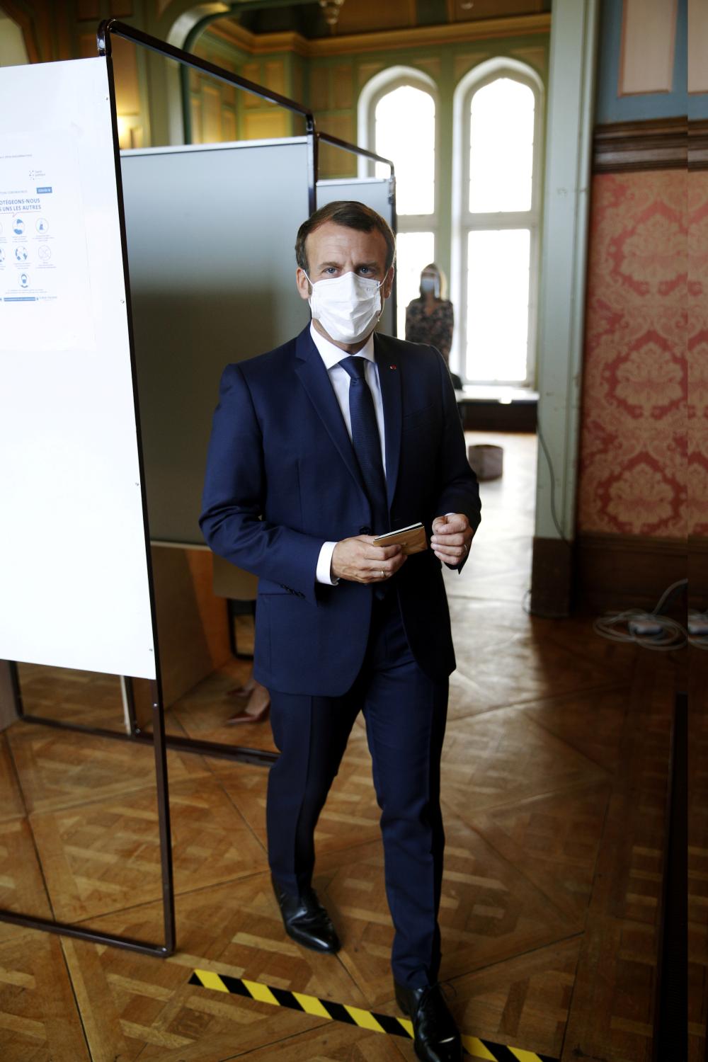 French President Emmanuel Macron wears a protective face mask as he exits a voting booth prior to casting his ballot at a polling station during the second round of French municipal elections, that was delayed due to the spread of the coronavirus disease (COVID-19), in Le Touquet-Paris-Plage, France June 28, 2020. Yoan Valat/Pool via REUTERS