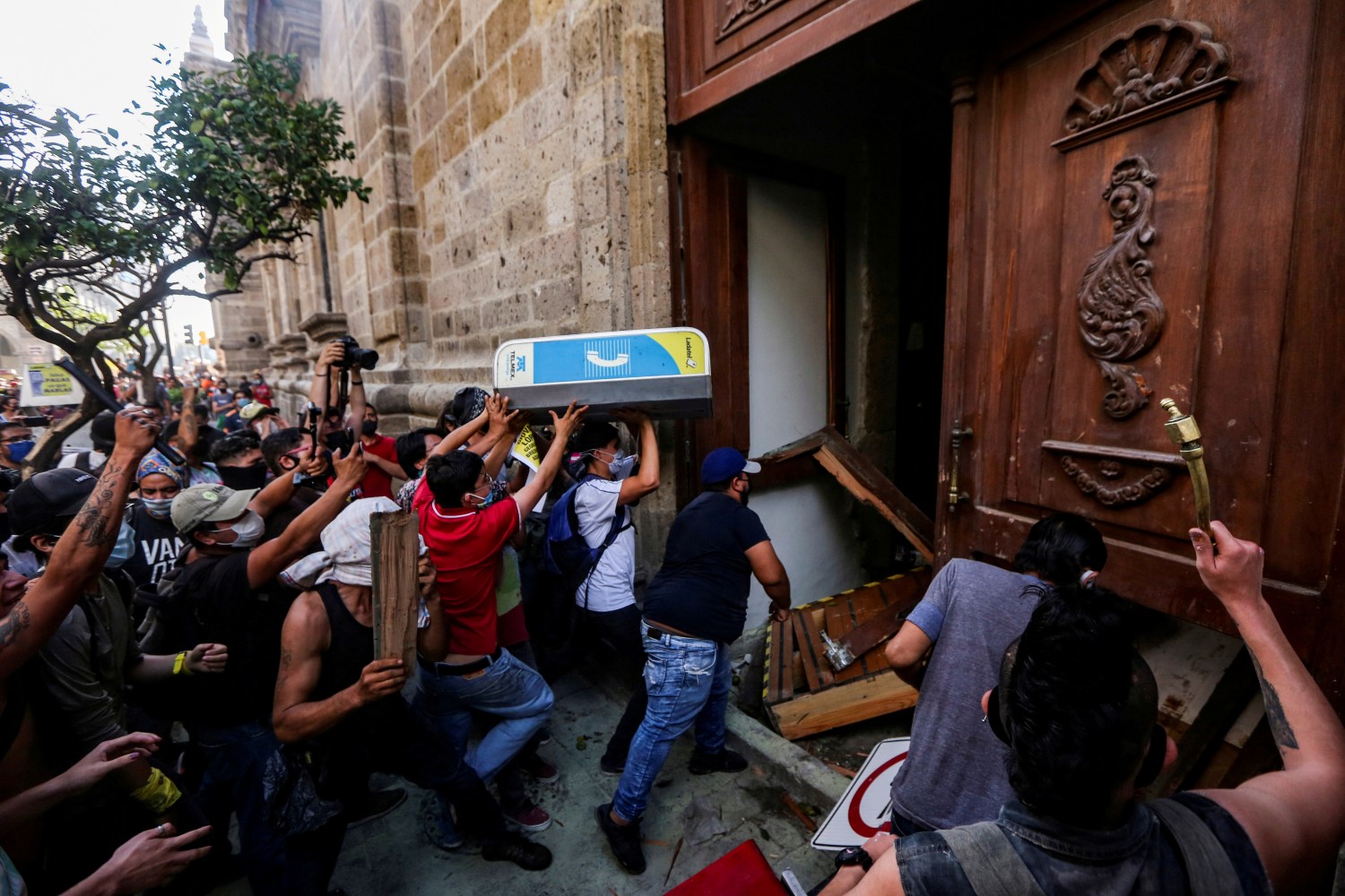 Demonstrators smash down a door of the Jalisco State Government Palace during a protest to demand justice for Giovanni Lopez, a construction worker who died after being arrested for not wearing a face mask in public, during the coronavirus disease (COVID-19) outbreak in Guadalajara, Mexico June 4, 2020. REUTERS/Fernando Carranza     TPX IMAGES OF THE DAY