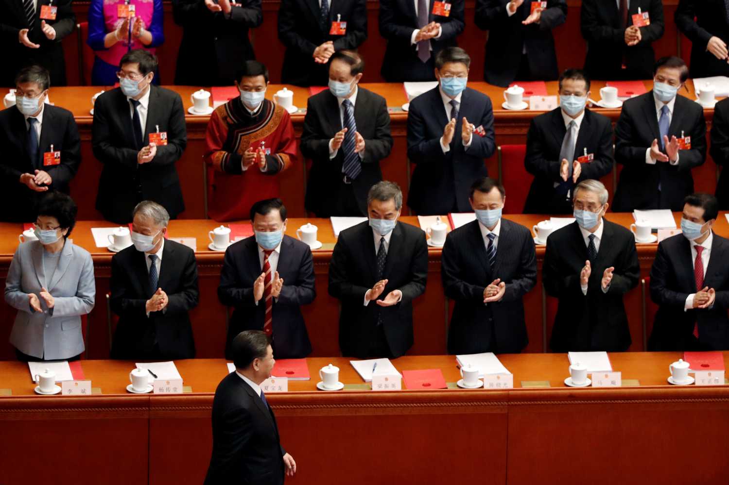 Chinese President Xi Jinping walks past officials wearing face masks following the coronavirus disease (COVID-19) outbreak as he arrives for the closing session of the National People's Congress (NPC) at the Great Hall of the People in Beijing, China May 28, 2020. REUTERS/Carlos Garcia Rawlins