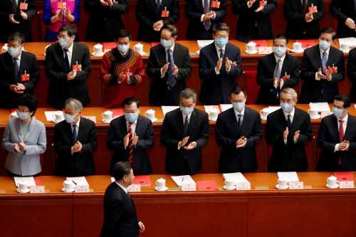 Chinese President Xi Jinping walks past officials wearing face masks following the coronavirus disease (COVID-19) outbreak as he arrives for the closing session of the National People's Congress (NPC) at the Great Hall of the People in Beijing, China May 28, 2020. REUTERS/Carlos Garcia Rawlins