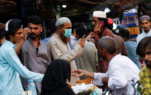 A man wearing a protective face mask as he gestures while shopping amid the rush of people outside an electronics market, after Pakistan started easing the lockdown restrictions, as the outbreak of the coronavirus disease (COVID-19) continues, in Karachi, Pakistan June 4, 2020. REUTERS/Akhtar Soomro
