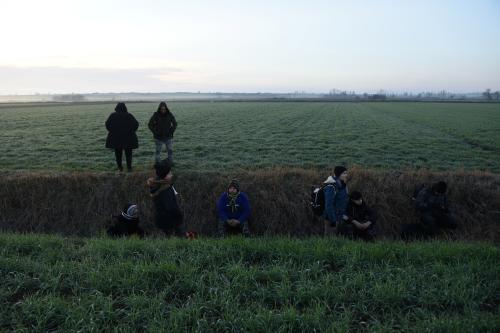 Migrants rest in a ditch, after crossing from Turkey to Greece, near the border crossing of Kastanies, Greece, March 2, 2020. REUTERS/Alexandros Avramidis