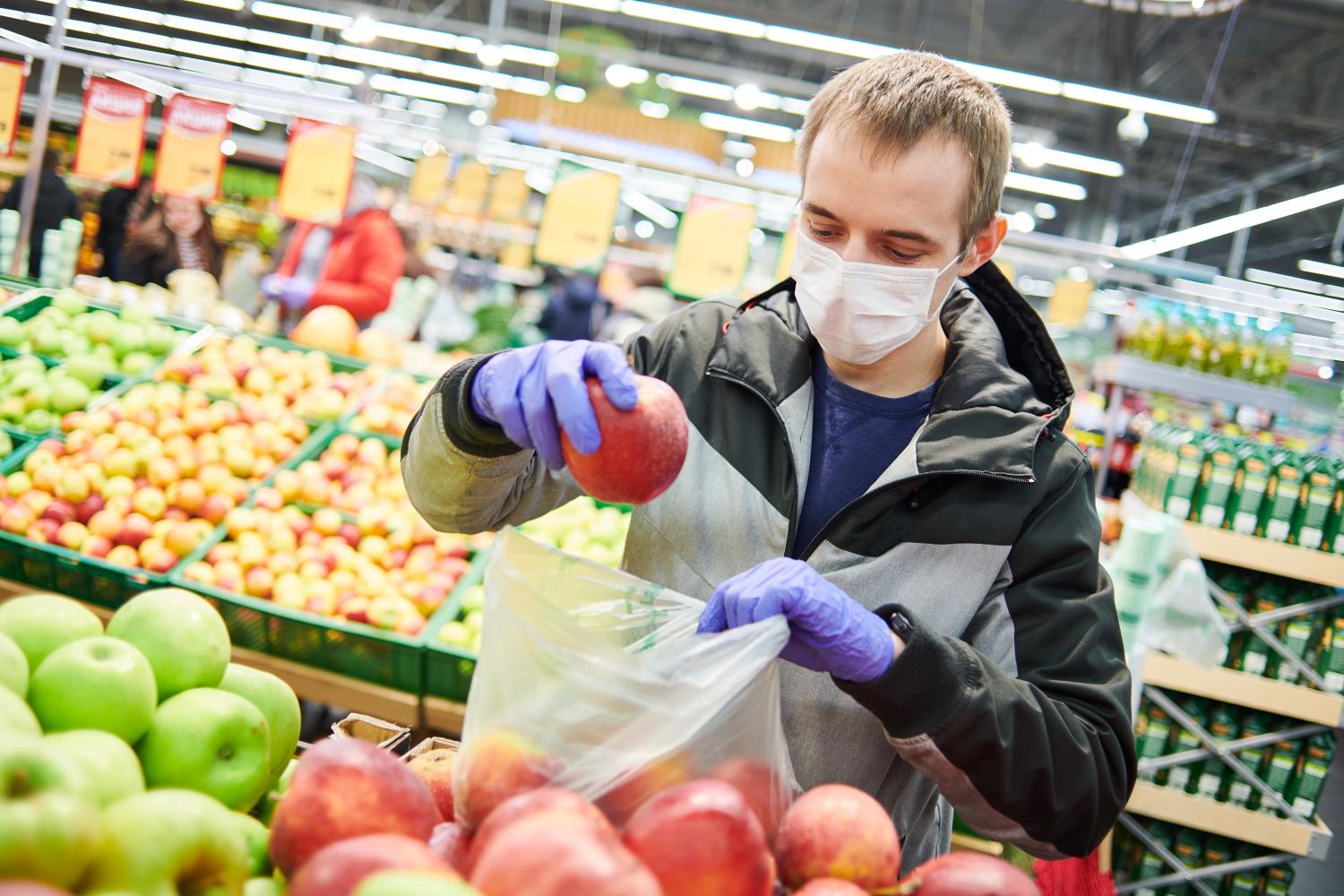 Man grocery shopping with COVID mask