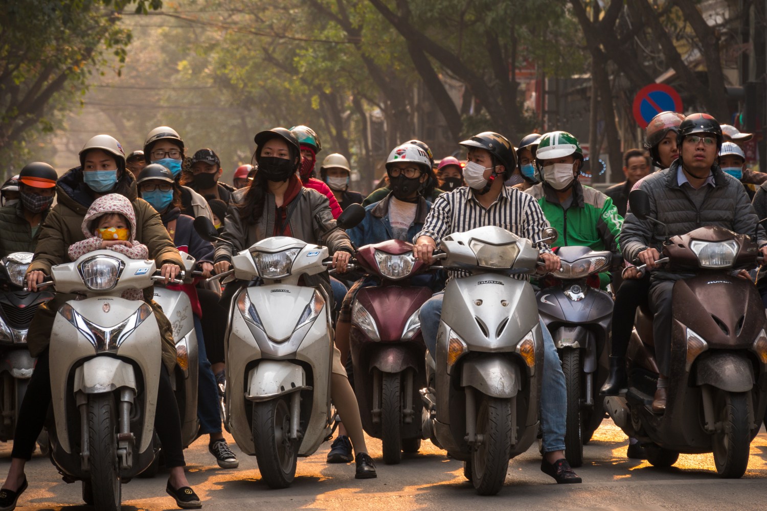 Vietnamese people wearing COVID-19 masks while riding scooters.