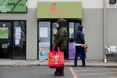 A woman with a face mask practices social distancing while waiting for food donations outside a food bank, as the spread of the coronavirus disease (COVID-19) continues, in Gypsum, Colorado, U.S., April 13, 2020.  REUTERS/Shannon Stapleton