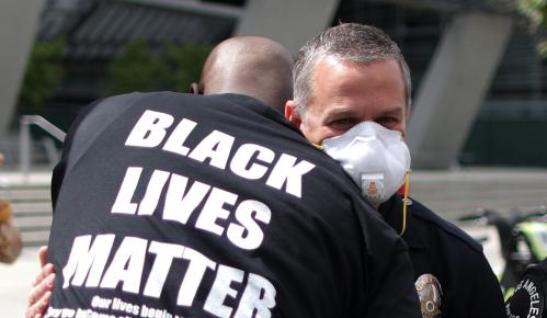 A demonstrator hugs a police officer during a protest against the death in Minneapolis police custody of George Floyd, outside LAPD headquarters in Los Angeles, California, U.S. June 2, 2020. REUTERS/Lucy Nicholson