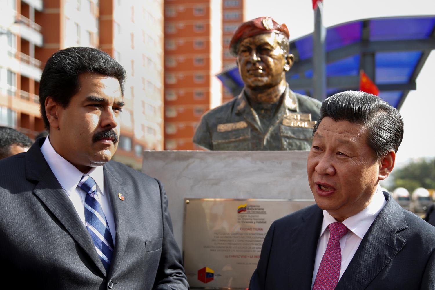 FILE PHOTO: FILE PHOTO: China's President Xi Jinping (R) speaks with Venezuela's President Nicolas Maduro in front of a statue of Venezuela's late president Hugo Chavez during a ceremony in Caracas July 21, 2014. China will provide Venezuela with a $4 billion credit line under an agreement signed on Monday, with the money to be repaid by oil shipments from OPEC member Venezuela. The deal was inked during a 24-hour visit to Venezuela by Xi, who is on a tour of Latin America. REUTERS/Carlos Garcia Rawlins/File Photo