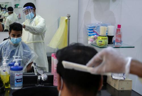 A barber wears a protective face shield and gloves as he cuts hair of a customer at a local barber shop after its reopening, following the outbreak of the coronavirus disease (COVID-19), in Riyadh, Saudi Arabia June 22, 2020. REUTERS/Ahmed Yosri
