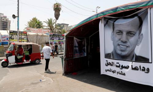 FILE PHOTO: A poster depicting the former government advisor and political analyst Hisham al-Hashemi, who was killed by gunmen is seen at the Tahrir Square in Baghdad, Iraq July 8, 2020. REUTERS/Thaier al-Sudani -/File Photo