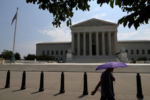 FILE PHOTO: A pedestrian holding an umbrella walks along First Street, as a series of rulings are issued at the United States Supreme Court in Washington, U.S., July 6, 2020. REUTERS/Tom Brenner/File Photo