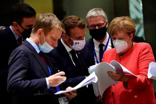 Spain's Prime Minister Pedro Sanchez, France's President Emmanuel Macron and German Chancellor Angela Merkel look into documents during the first face-to-face EU summit since the coronavirus disease (COVID-19) outbreak, in Brussels, Belgium July 20, 2020. John Thys/Pool via REUTERS