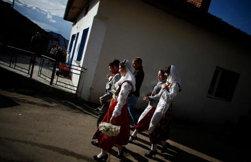 Bulgarian Muslims Mehmed Aiumankov (L), and his bride Fatme Kichukova (2nd L) walk with their friends during their wedding ceremony in the village of Ribnovo, in the Rhodope Mountains, some 210 km (130 miles) south of Sofia December 11, 2011. The remote mountain village of Ribnovo in southwest Bulgaria has kept its traditional winter marriage ceremony alive despite decades of Communist persecution, followed by poverty that forced many men to seek work abroad. The wedding ritual was resurrected with vigour among the Pomaks - Slavs who converted to Islam under Ottoman rule. Today Muslims make up 10 percent of Bulgaria's 7.4 million population. The highlight of the ceremony is the painting of the bride's face, where in a private rite open only to female in-laws, her face is covered in thick, chalky white paint and decorated with colourful sequins. Picture taken December 11, 2011. REUTERS/Stoyan Nenov (BULGARIA - Tags: SOCIETY RELIGION)