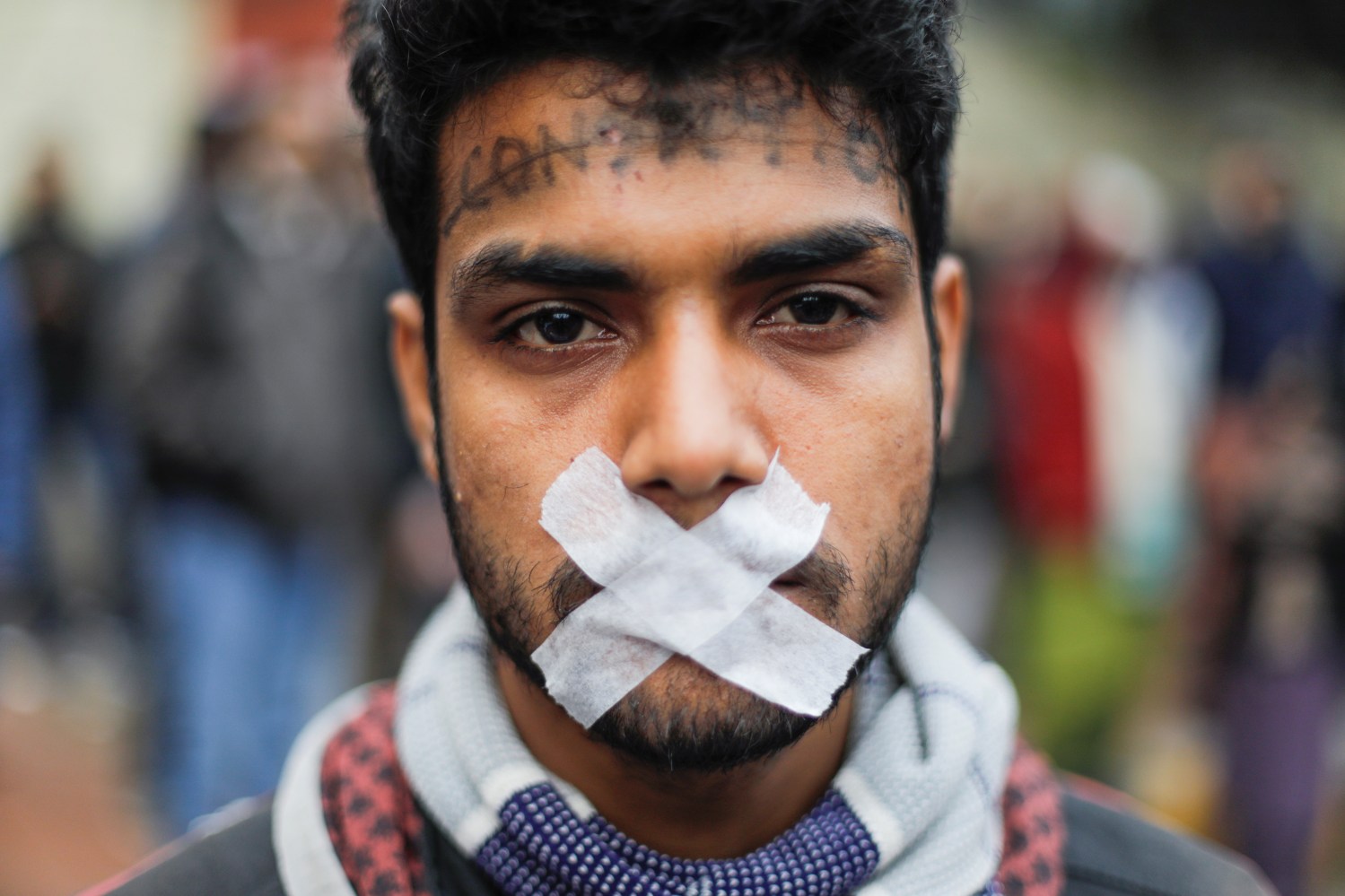 A protester with tapes over his mouth attends a protest against a new citizenship law in Delhi, India, December 19, 2019. REUTERS/Adnan Abidi