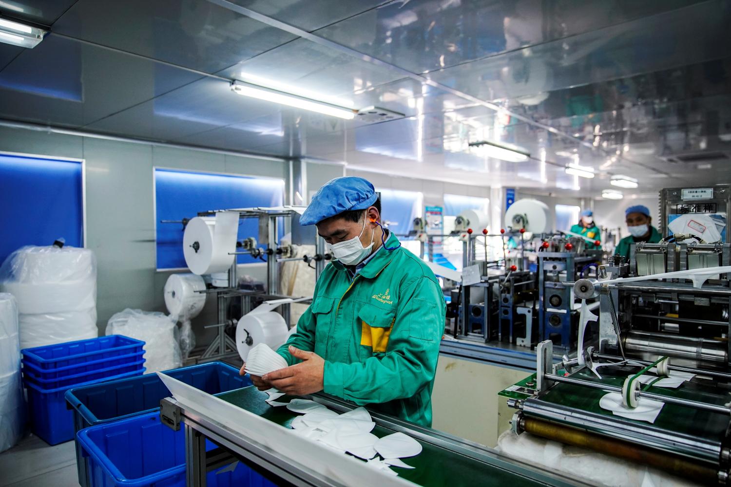 FILE PHOTO: Workers are seen on a production line manufacturing masks at a factory in Shanghai, China January 31, 2020. Picture taken January 31, 2020. REUTERS/Aly Song/File Photo