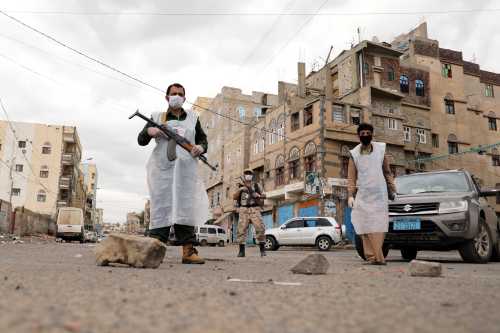 Security men wearing protective masks stand on a street during a 24-hour curfew amid concerns about the spread of the coronavirus disease (COVID-19), in Sanaa, Yemen May 6, 2020. REUTERS/Khaled Abdullah     TPX IMAGES OF THE DAY