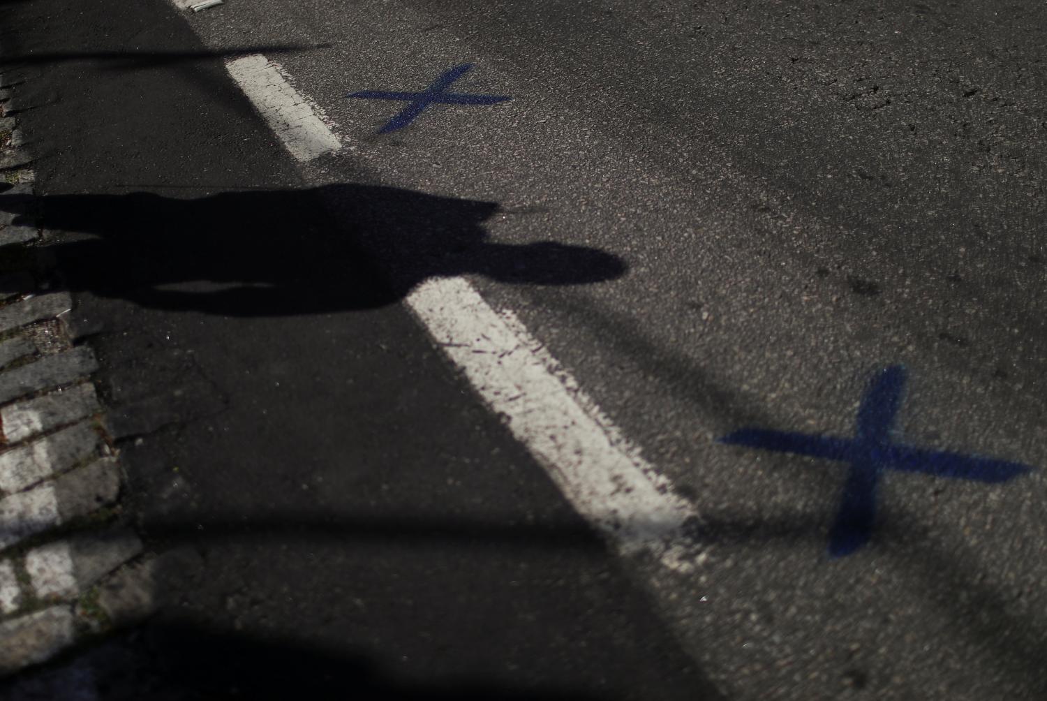 A silhouette of a person is seen next to the marks for social distancing outside the Caixa public bank, as people wait to receive emergency aid given by the federal government to the most vulnerable, following the coronavirus disease (COVID-19) outbreak, in Rio de Janeiro, Brazil May 5, 2020. REUTERS/Pilar Olivares