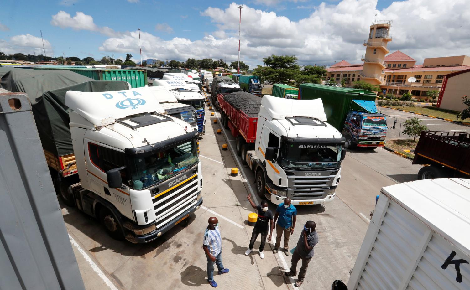 Truck drivers wait near their parked vehicles for the coronavirus disease (COVID-19) test results at the Namanga one stop border crossing point between Kenya and Tanzania, in Namanga, Kenya May 12, 2020. REUTERS/Thomas Mukoya