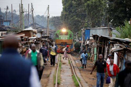 A woman crosses a railway track just as a train approaches a makeshift train station in the Kibera slum of Nairobi, Kenya, November 29, 2019. REUTERS/Baz Ratner      SEARCH "MOMBASA–NAIROBI TRAIN" FOR THIS STORY. SEARCH "WIDER IMAGE" FOR ALL STORIES.